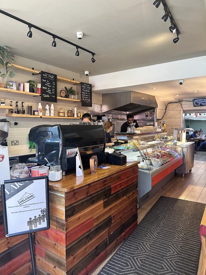 The espresso machine and counter, staff working behind.