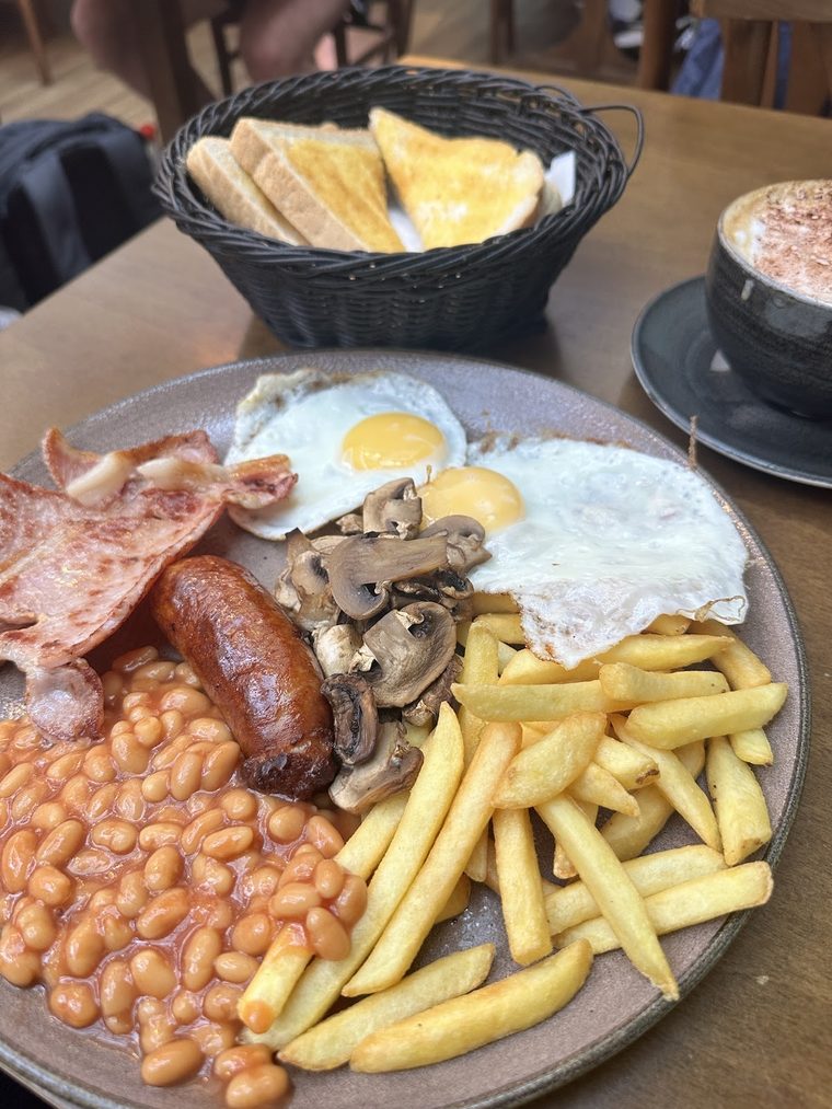 Full English breakfast with a basket of toast.